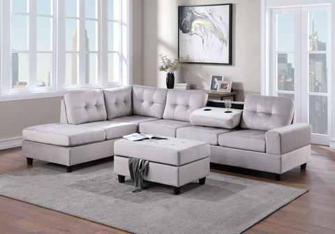 Silver velvet reversible tufted sectional with drop down cup holders and storage ottoman